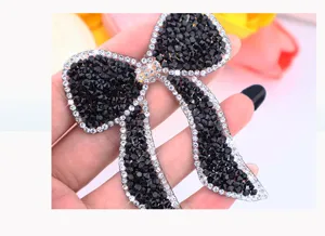 Close-up detail of shimmering black rhinestone bow patch, exquisite craftsmanship.