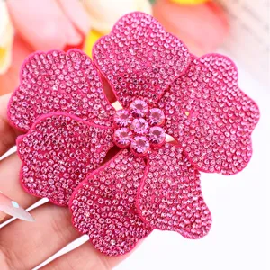 Close-up shot of shiny pink rhinestone flower patch, sparkling crystal details for DIY crafts.