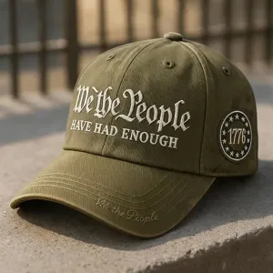 Dettaglio cappellino da baseball ricamato verde militare con slogan e patch laterale.