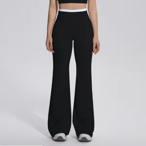 Gros plan détail de pantalon de yoga taille haute avec ceinture contrastée blanche et évasée.