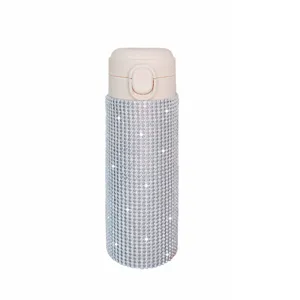 Close-up detail of rhinestone insulated water bottle with sparkling crystals and pink lid.