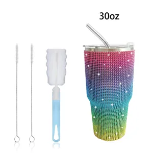 Detail shot of 30oz rhinestone tumbler with straw and cleaning brushes set against white bg.