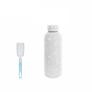 Detailed close-up view of the sparkling rhinestone thermos bottle and cleaning brush.