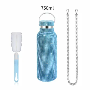 Close-up view of the sparkling rhinestone water bottle, matching cleaning brush and metal chain.