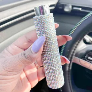 Primo piano dettagliato del flacone di profumo spray da viaggio scintillante di strass.