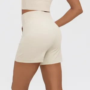 Detail view of beige high waist athletic fitness shorts featuring side pockets and sleek fit.