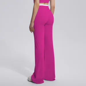Pantalon de yoga évasé à taille haute avec ceinture contrastée, détail de sport chic.