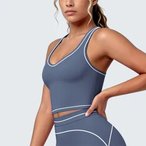 Detailopname van een sportbeha voor dames in stofblauw met witte bies en legging.