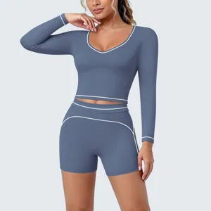Detailed view of dust blue long sleeve yoga crop top and shorts set with white trim.