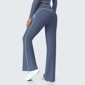 Close-up of high-waisted grey-blue flared yoga pants with white contrast piping details.