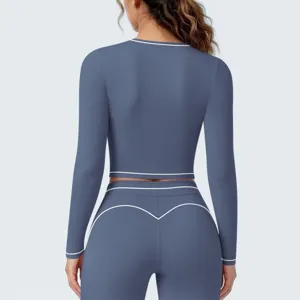 Achterdetail van de blauwe sport crop top met lange mouwen en bijhorende fitnessleggings.