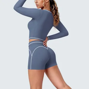Detail view of the blue long sleeve and shorts yoga set featuring stylish white contrast piping.