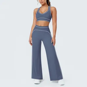 Completo sportivo yoga da donna, reggiseno blu e pantaloni larghi con profili bianchi.