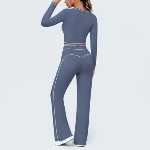 Rückdetail des blauen Langarm-Crop-Tops und Schlag-Yogahosen mit weißem Paspelbesatz.