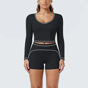 Black long sleeve crop top and shorts yoga set with white piping for fitness and running.