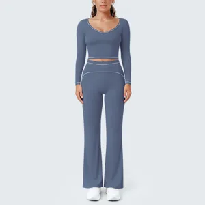 Detailansicht des blauen Langarm-Crop-Tops und der Schlag-Yogahosen mit Paspelierung.