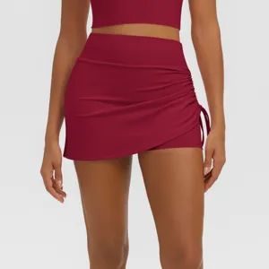 Closeup detail of high-waist ruched fake two-piece yoga skort, breathable elastic activewear.