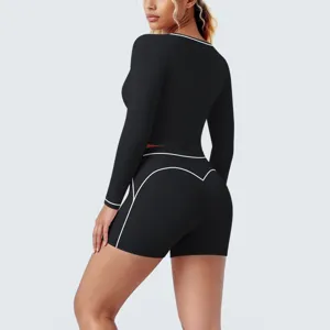 Black long sleeve crop top and shorts athletic yoga set with stylish white piping details.