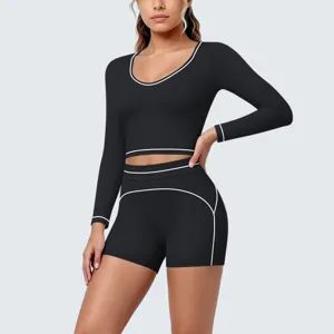 Black long sleeve crop top and shorts yoga set with white contrast piping for fitness.
