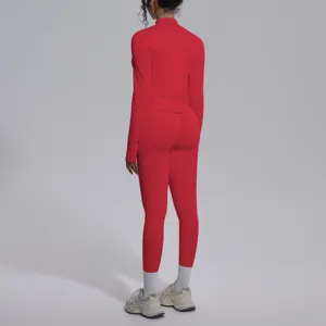 Top sportivo a maniche lunghe rosso senza cuciture e leggings, vista di dettaglio professionale.