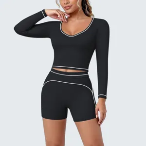 Close-up detail of the black long sleeve crop top and shorts yoga set featuring contrast piping.