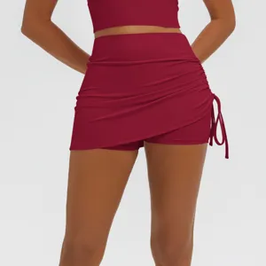 Red high-waisted side-ruched fitness yoga skirt with built-in shorts for active workout style.
