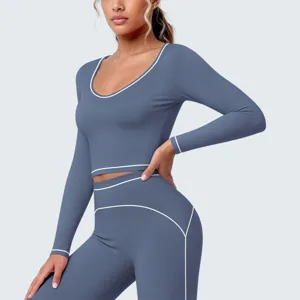 Nahaufnahme des schieferblauen Langarm-Crop-Tops mit weißem Kontrastbesatz und passenden Tights.