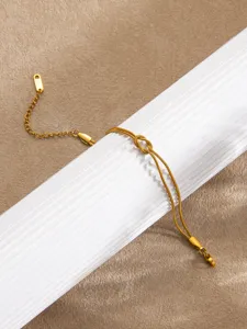Vue détaillée d'un bracelet de chaîne serpent en or avec un design de nœud élégant et chaîne.