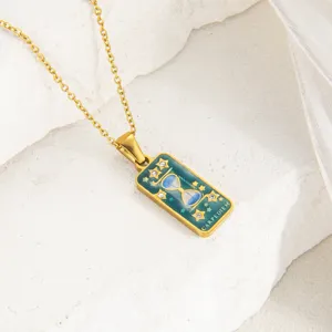 Detalle del colgante de collar con tarjeta de tarot dorada, esmalte y cadena fina elegante.