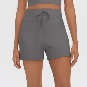 High waist athletic shorts featuring convenient side pockets and adjustable drawstring. Detail.