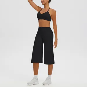 Détail ensemble yoga noir, soutien-gorge de sport respirant et pantalon capri pour fitness.