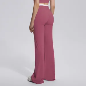 Détail de pantalon de yoga évasé à taille haute montrant la ceinture contrastée.