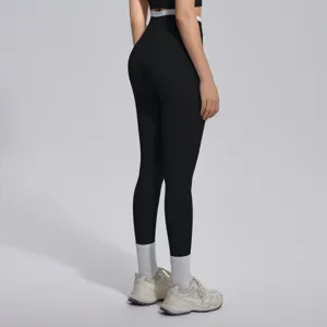 Vue détaillée de leggings de yoga noirs taille haute avec ceinture blanche contrastante.
