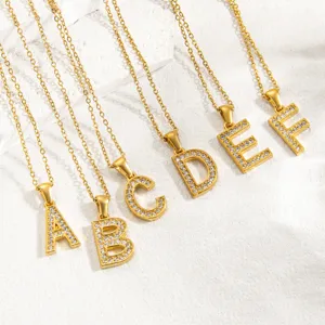 Nahaufnahme von strassbesetzten Buchstaben Ketten Anhängern in glänzendem Goldton.