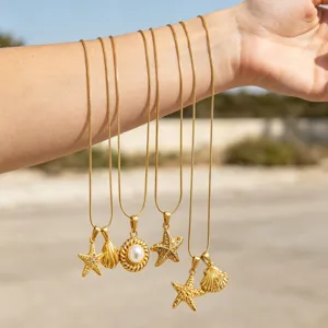 Detailaufnahme von goldenen Ozean Halsketten mit Seestern und Perlen Anhängern am Arm