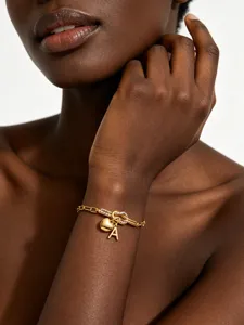 Goldener Titanstahl Armband mit Herz und Buchstabe Anhänger für Damen Schmuck Detail.