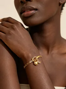 Goldfarbenes Titanstahl-Knotenarmband mit funkelnden Zirkonia, Herzanhänger und Buchstabe E.