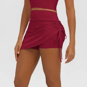 Detailed view of dark red side drawstring ruched fake two-piece yoga athletic shorts skirt.
