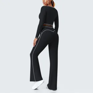 Schwarzes Yoga-Fitness-Set mit kontrastierenden Paspeln, Langarm-Top und Schlaghose.