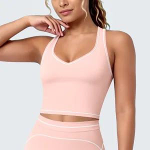 Roze sport crop top detail met contrasterende witte biezen en racerback ontwerp.