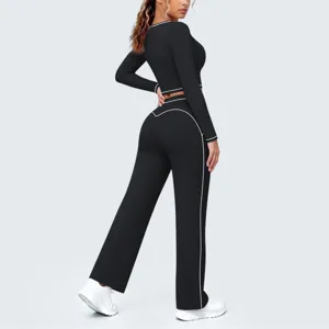 Detailansicht des schwarzen langarm Crop-Tops und Schlag-Yogahosen-Sets mit weißer Paspelierung.