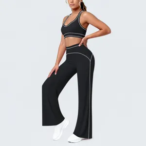 Completo yoga nero in due pezzi abbigliamento sportivo con profili bianchi a contrasto.