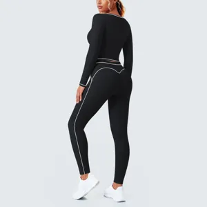 Detail view of black activewear set featuring contrast white piping, long sleeves and leggings.