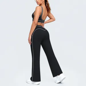 Completo yoga nero con profili a contrasto, reggiseno sportivo e pantaloni a zampa.