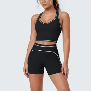 Close-up detail view of black athletic yoga set featuring stylish white contrast piping trim.