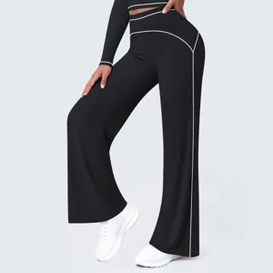 Detail view of high waist black wide leg athletic pants with white contrast piping.