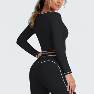 Achterkant detail van zwarte sporttop en leggings met witte bies, hoog rekbaar.