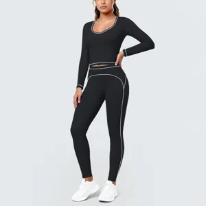 Black long sleeve fitness crop top and leggings set with white contrast piping details.