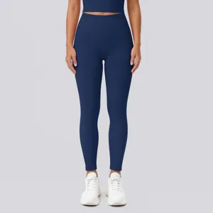 High-waisted solid navy blue fitness yoga leggings with crop top and white sneakers detail.
