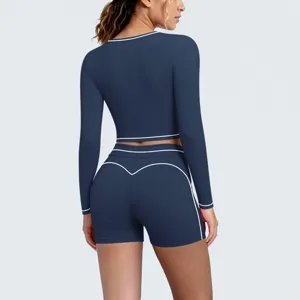 Detailed view of the dark blue long sleeve crop top and shorts set with white piping.